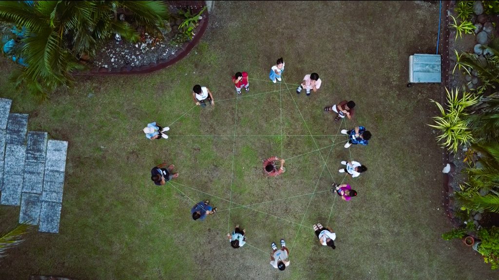 Aerial shot of students making geographical design with string.